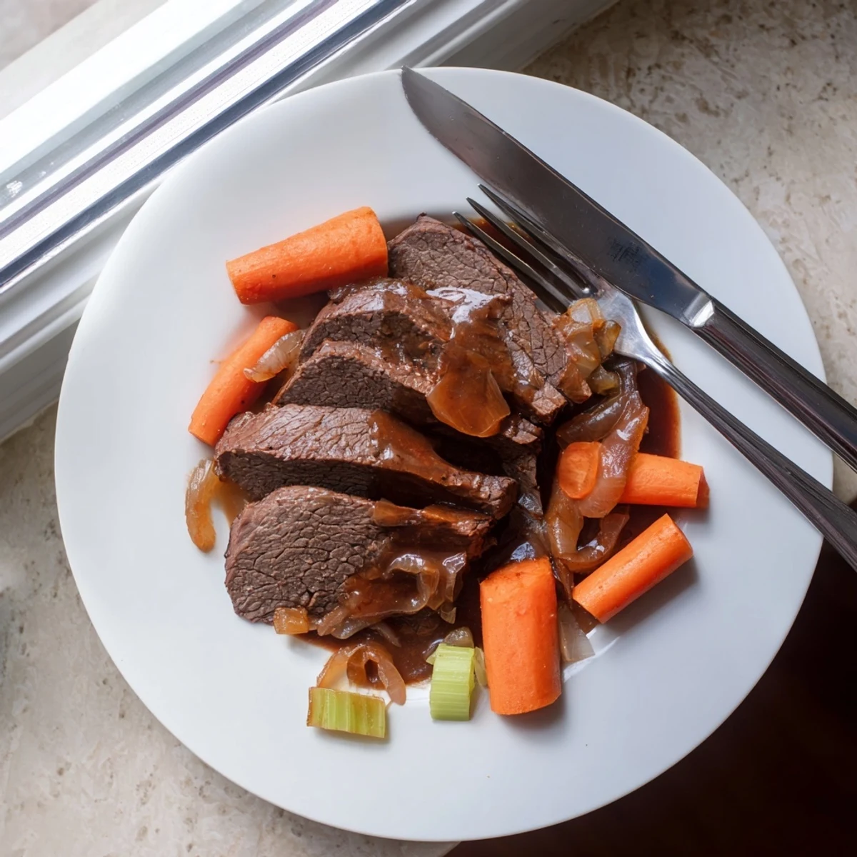 Succulent slow cooker beef brisket slices resting on a bed of tender caramelized vegetables