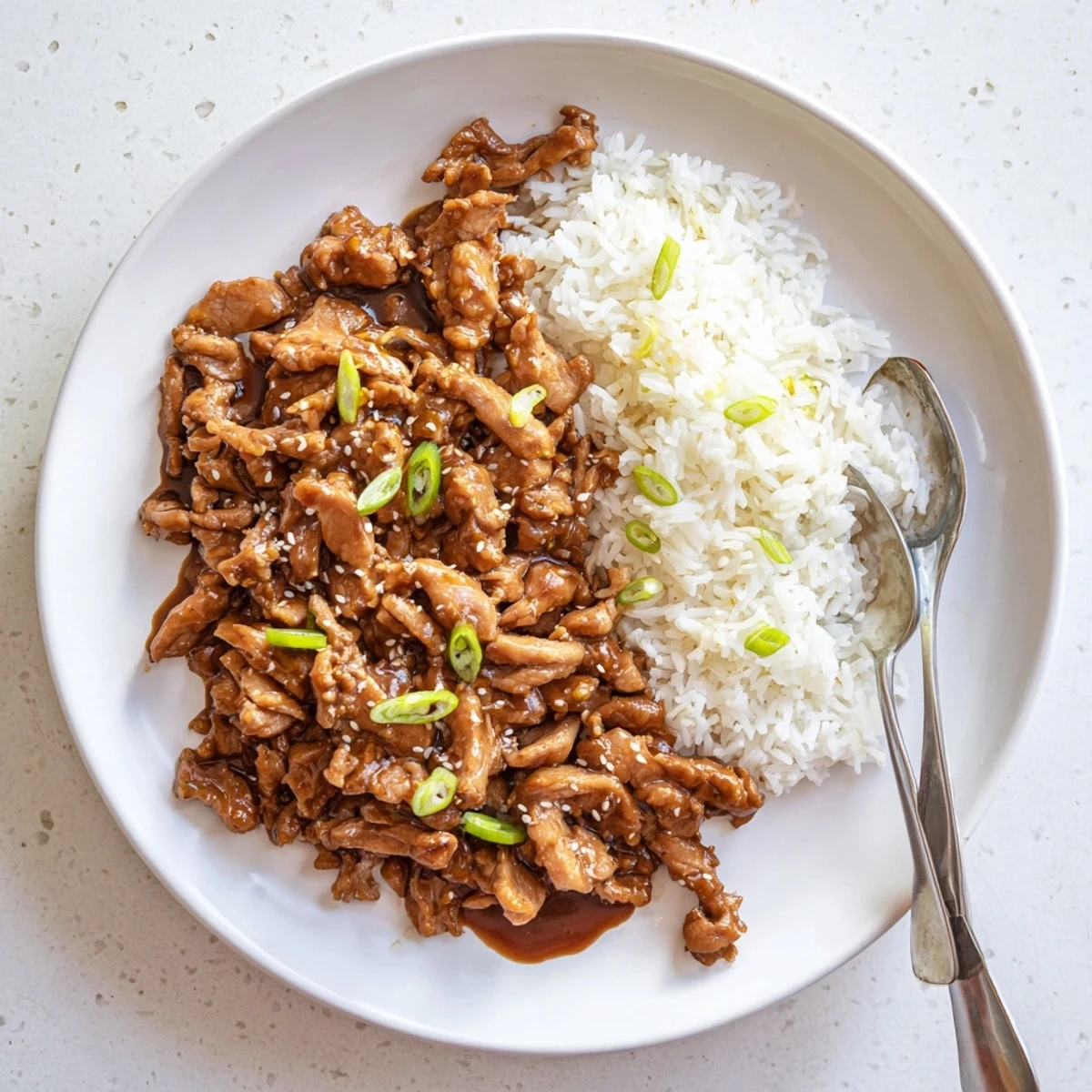 Rich and saucy Mongolian chicken in a slow cooker bowl, featuring shredded meat in a sweet soy glaze