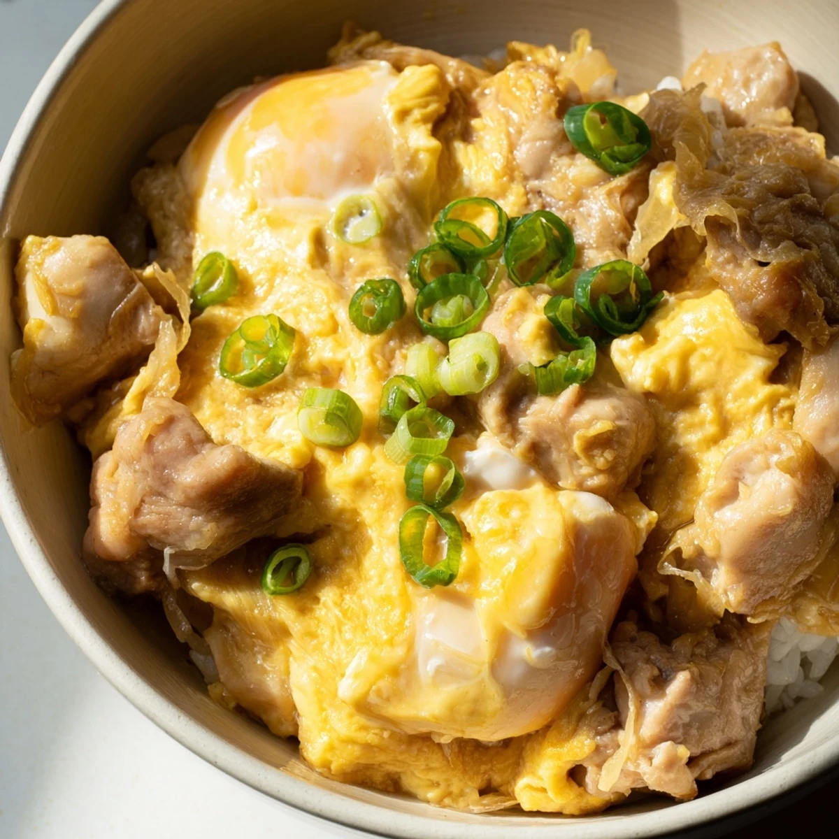 Comforting Oyakodon Japanese rice bowl with savory chicken onion and fluffy egg topping