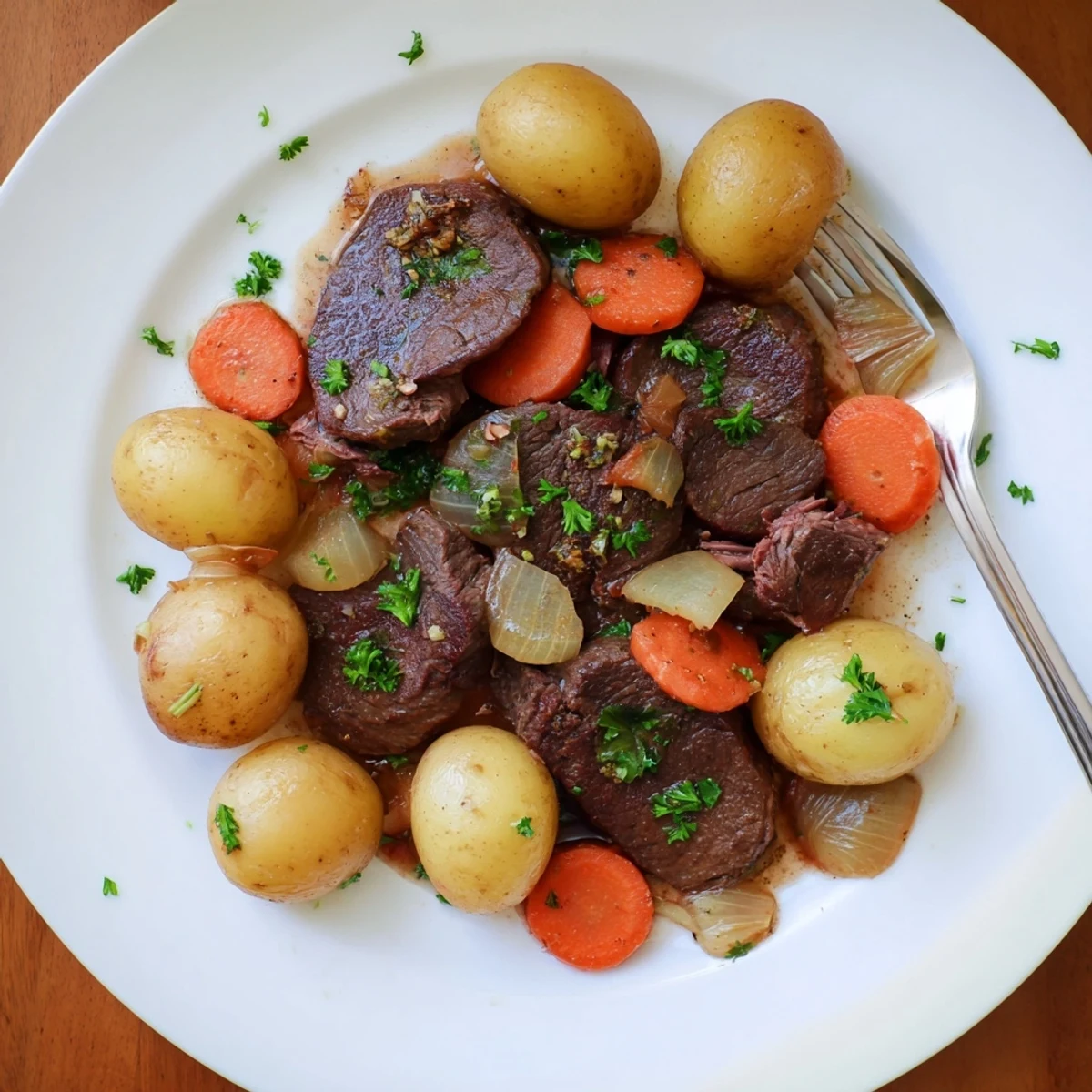 Hearty slow cooker steak and potatoes dish garnished with fresh parsley served family style