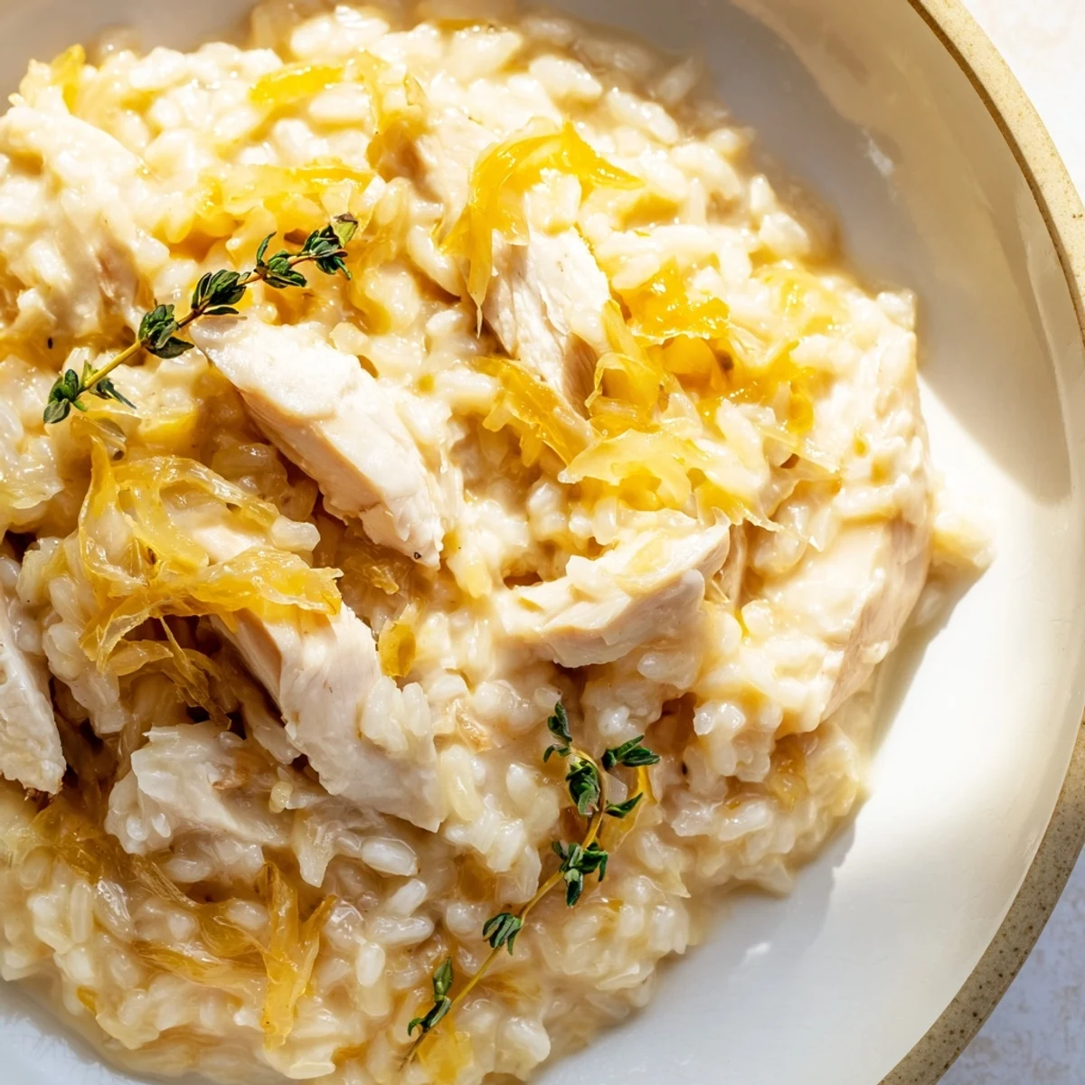 Golden brown chicken breasts nestled in caramelized onions and rice with a rich, velvety cream sauce