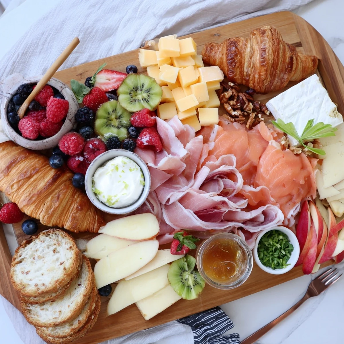 Savory breakfast charcuterie board featuring smoked salmon, boiled eggs, sliced fruits, and honey for easy morning grazing