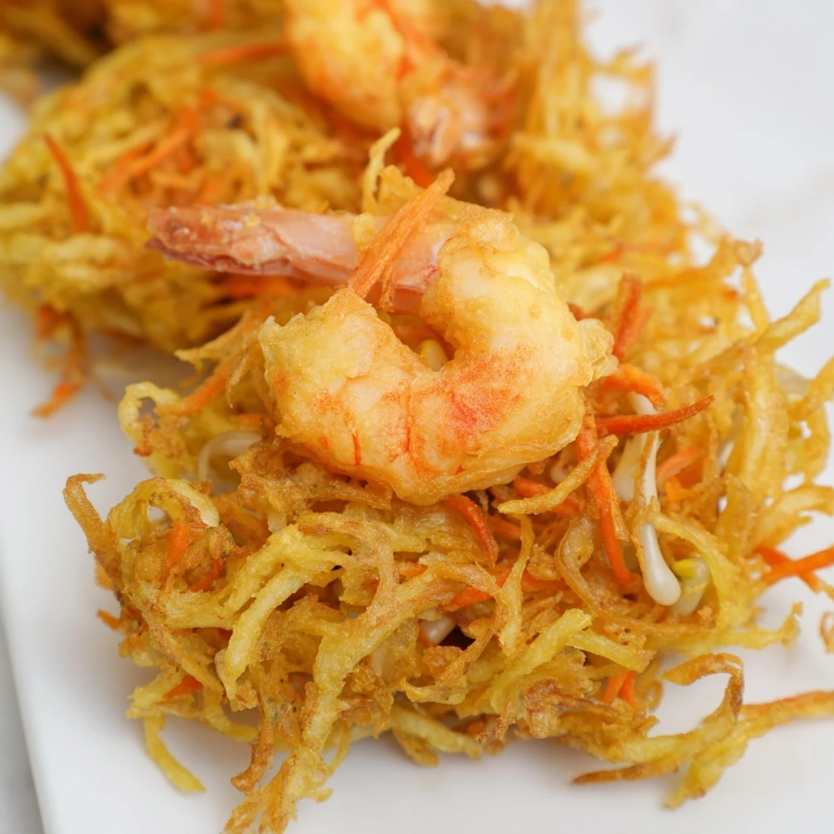 Ukoy Filipino shrimp fritters loaded with bean sprouts and carrots fried until perfectly golden brown