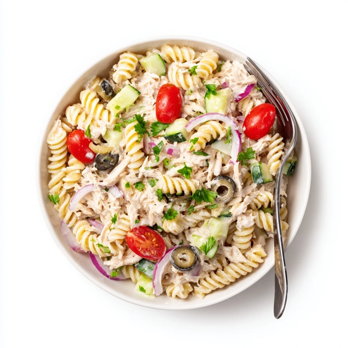 Creamy tuna pasta salad in a white bowl with cherry tomatoes and fresh parsley sprinkled on top