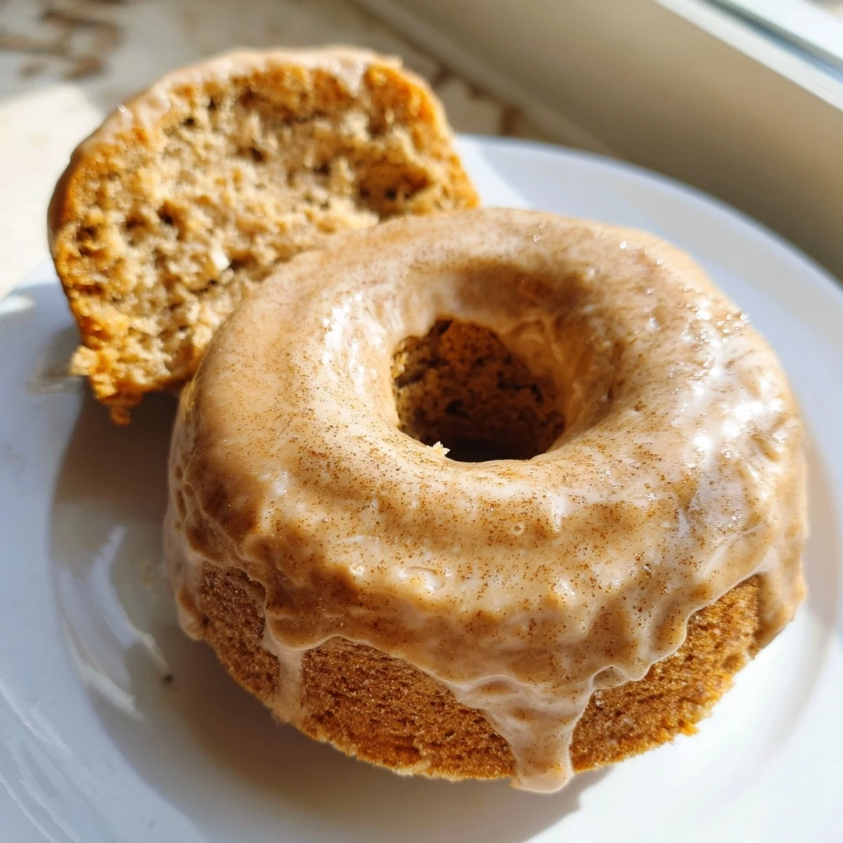 Golden banana bread donuts topped with sweet cinnamon glaze on a wire rack