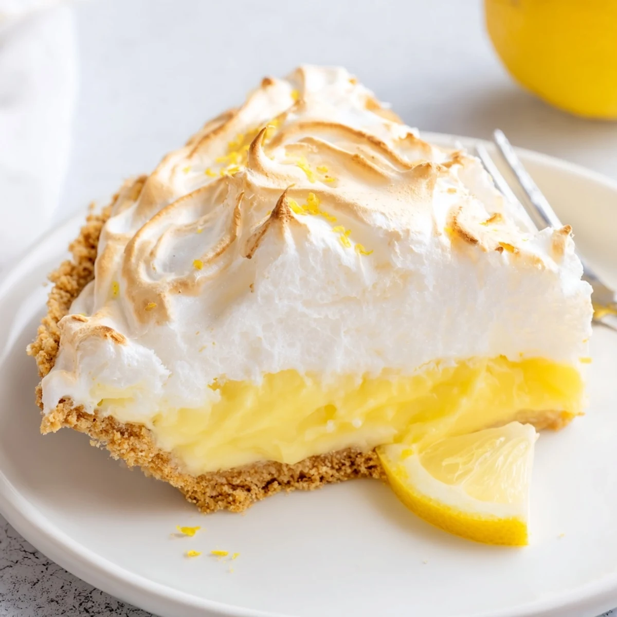 Creamy real lemon pie recipe with golden meringue towering over a buttery graham crust