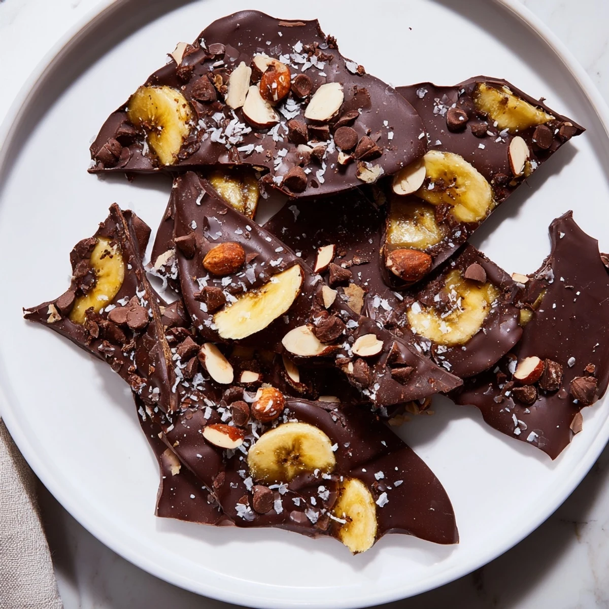 Creamy chocolate banana bark topped with roasted nuts and flaky sea salt