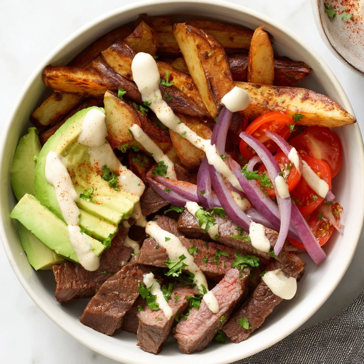 Golden steak strips crispy fries bowl topped with fresh halved cherry tomatoes